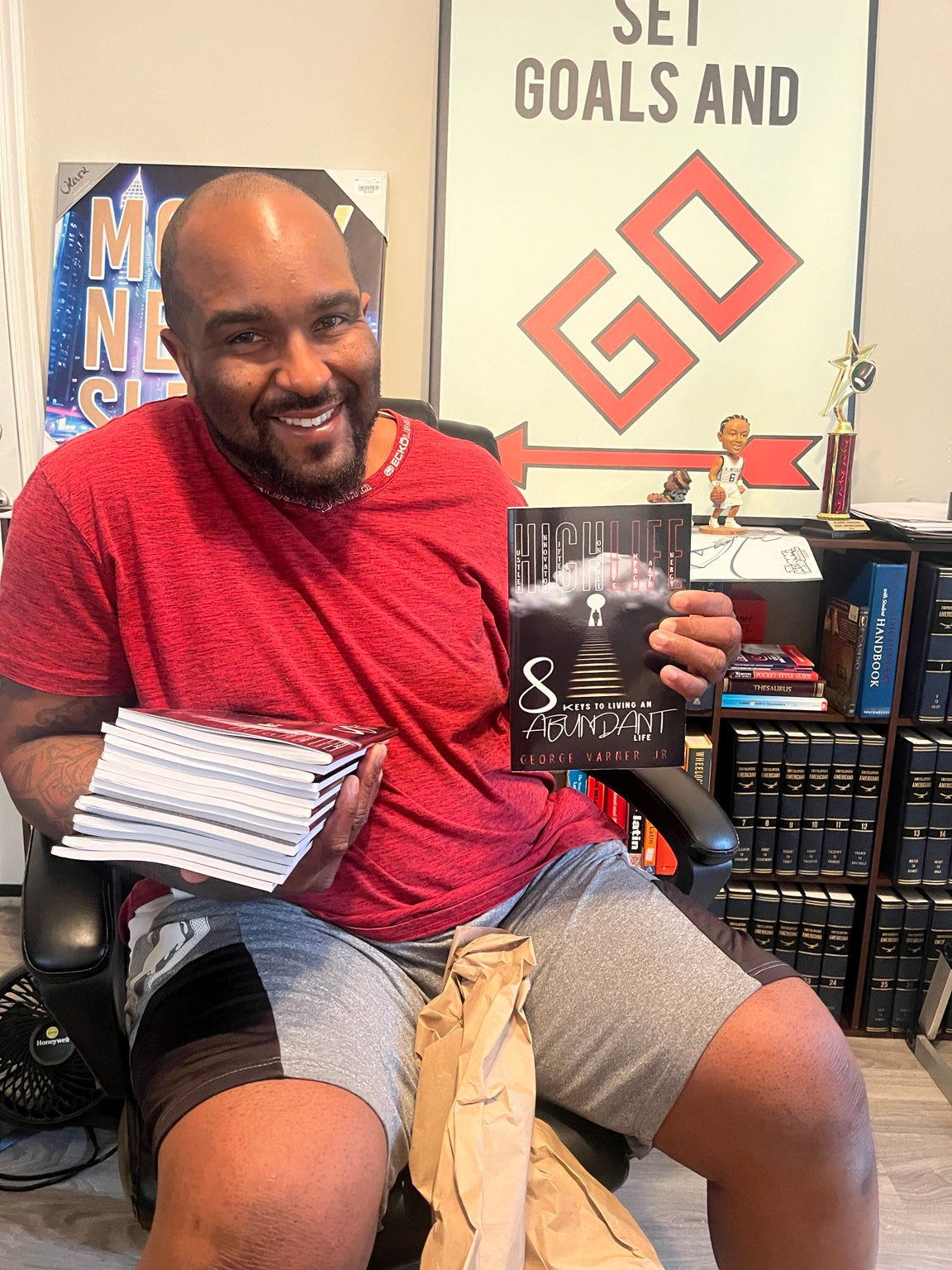 Author George Varner Jr. holding HIGHLIFE: 8 Keys to Living an Abundant Life with physical copies